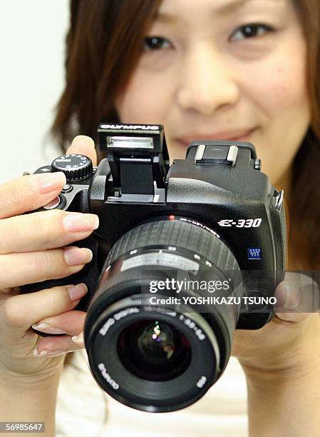 Japan's camera giant Olympus employee displays the new style SLR digital camera "E-330", equipped with a 7.5 mega-pixel Live MOS image sensor and the...