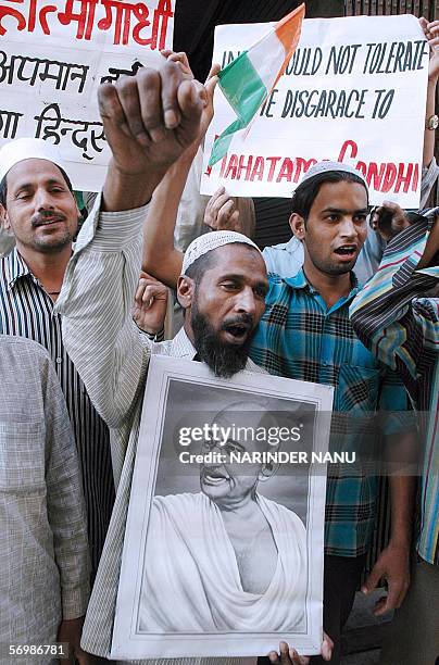 Indian demonstrators shout slogans as they hold placards protesting over US security personnel taking sniffer dogs to check the safety of a memorial...