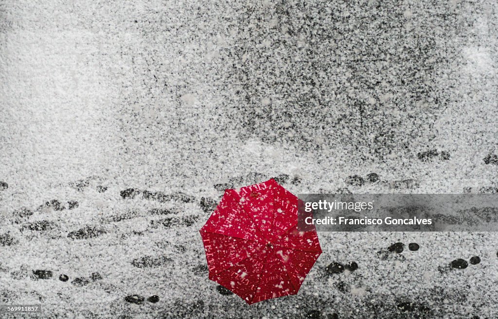 Red umbrella during a snowfall in Barcelona