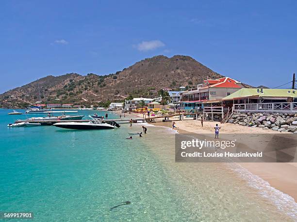 the beach and waterfront at grand case, st martin - saint martin caraibi stock-fotos und bilder