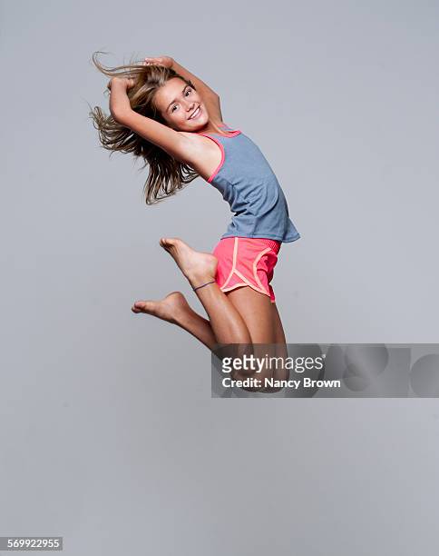 caucasian eleven year old girl jumping for joy - 10 year fotografías e imágenes de stock