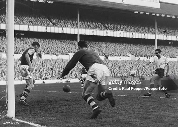 Tottenham Hotspur football player Cliff Jones fails to score as Burnley player Brian Miller kicks the ball away from the goal line, with Burnley...