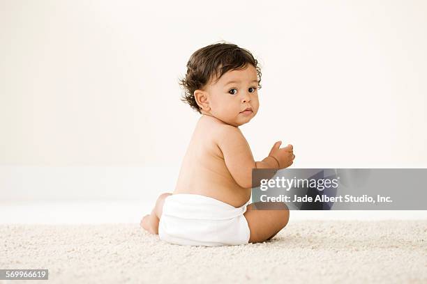 baby girl in diaper looking over her shoulder - baby diaper stock-fotos und bilder