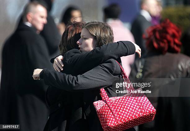 Mourners hug as they exit the Gormley Funeral Home after attending the funeral service for John Jay graduate student Imette St. Guillen March 4, 2006...