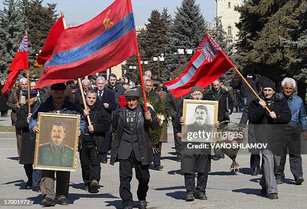 Georgians hold portraits of former Soviet dictator Joseph Stalin commemorating the 53rd anniversary of his death in the Georgian town of Gori, some...