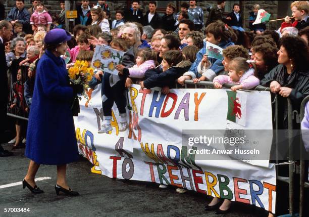 Queen Elizabeth II gets greeted by the crowds when she pays a visit to on her Birthday, April 21, 1989 in Treherbert, Wales.