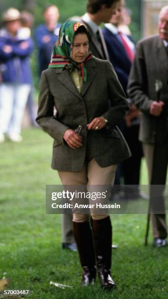 Queen Elizabeth ll walks in riding gear as she visits the Royal Windsor Horse Show in May 1988 in Windsor, England.