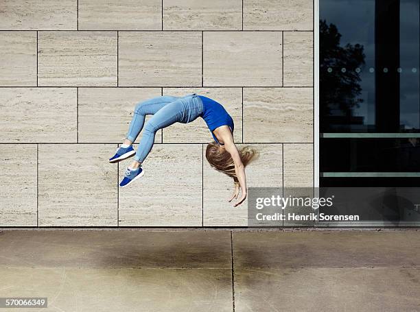 woman doing a backflip - salto de espalda fotografías e imágenes de stock