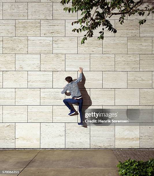 man climbing wall - down blouse stockfoto's en -beelden