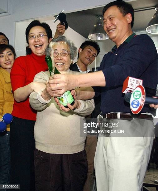 Taiwan-born director Ang Lee's brother Kang Lee mother Si-chuang Yang Lee and Kang Lee's wife Chen Huan-hua pop a bottle of champaign after Ang Lee...
