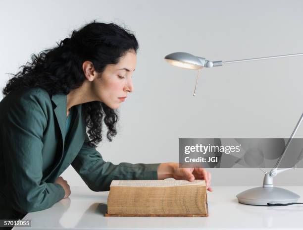 woman reading thick book - dizionario foto e immagini stock