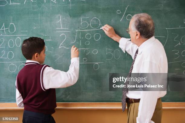 teacher and student doing mathematics on the chalkboard - dominikanischer abstammung stock-fotos und bilder