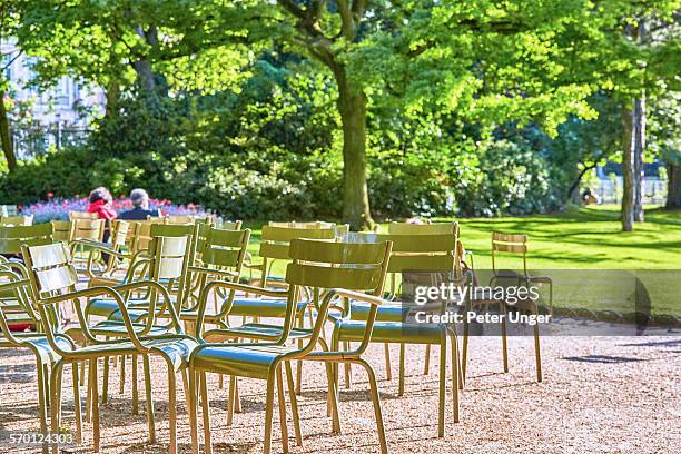 people resting in the sun on chairs in park - リュクサンブール公園 ストックフォトと画像