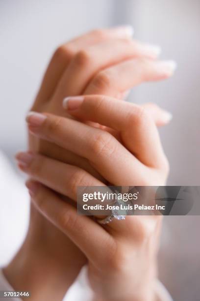 young woman's manicured nails wearing an engagement ring - diamantring stock-fotos und bilder