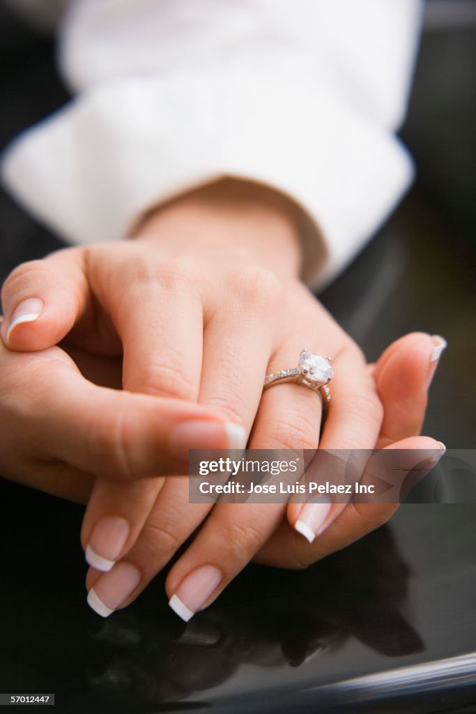 Young woman's manicured nails wearing an engagement ring