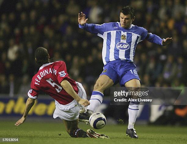 Lee McCulloch of Wigan Athletic is tackled by Rio Ferdinand of Manchester United during the Barclays Premiership match between Wigan Athletic and...