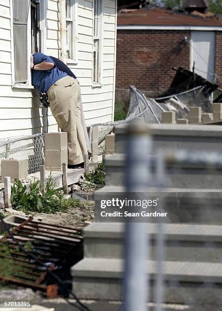 Officials look inside of a home in the Lower Ninth Ward March 6, 2006 in New Orleans, Louisiana. A new push to find bodies among the debris and...