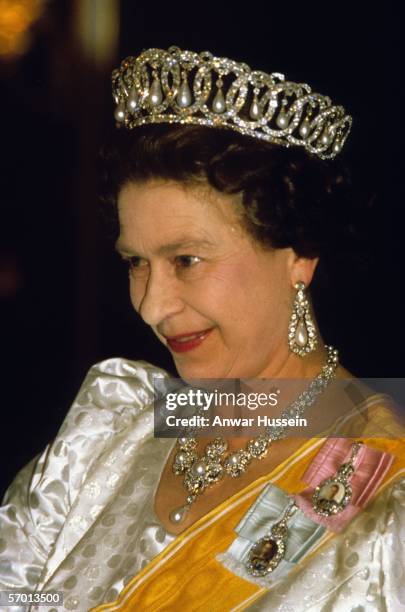 Queen Elizabeth ll, wearing a diamond and pearl tiara and the jubilee necklace, smiles as she attends a State Banquet during her official visit in...