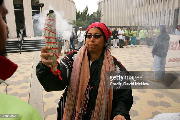 Sylvia Hererra performs a cleansing ceremony using the smoke of sage during a vigil in front of the Pomona City Hall as day laborers continue their...