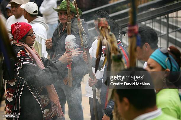 Sylvia Hererra performs a cleansing ceremony on runners using the smoke of sage during a vigil in front of the Pomona City Hall as day laborers...