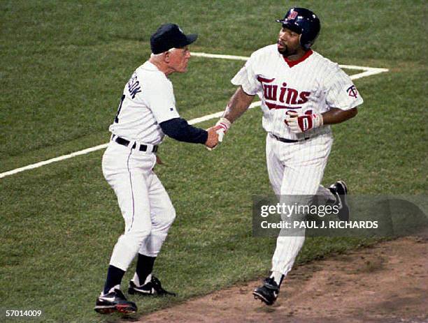 This file photo dated 13 July 1993 shows Minnesota Twins player Kirby Puckett getting a handshake from third base coach Detroit Tigers manager Sparky...