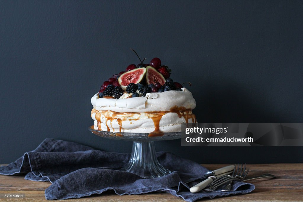 Pavlova decorated with berries on a cake stand