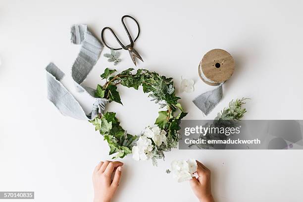 girl's hands making a festive christmas foliage wreath - wreath making stock pictures, royalty-free photos & images