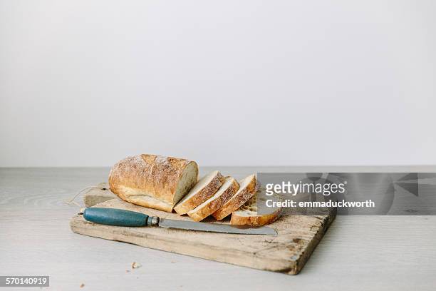 loaf of sliced bread on a chopping board - immagine on white board foto e immagini stock