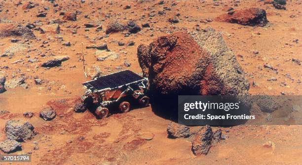 The Sojourner Rover uses its Alpha Proton X-Ray Spectrometer to analyse the Yogi Rock on the surface of Mars, during the Mars Pathfinder exploratory...