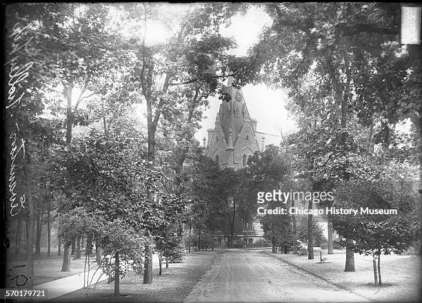 Exterior view of University Hall at Northwestern University, looking down a path leading toward the building, Evanston, Illinois, 1900s. This image...