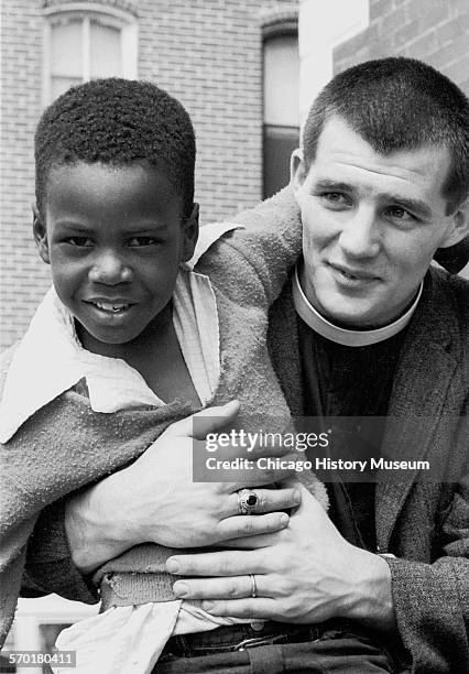 Minister holds a boy in front of the Brown Chapel AME Church, Selma, Alabama, 1965.