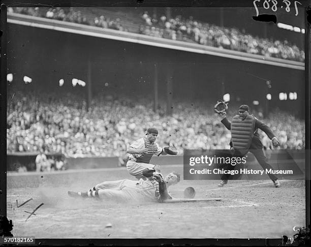 Cleveland Indians baseball player sliding into home plate at Comiskey Park, Chicago, Illinois, circa 1930.