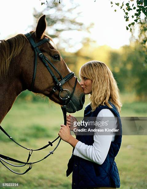 a woman kissing a horse. - muzzle human stock pictures, royalty-free photos & images