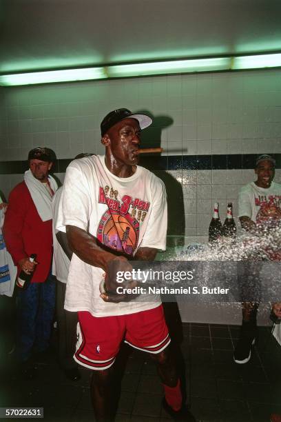 Michael Jordan of the Chicago Bulls celebrates in the locker room while spraying champagne after defeating the Utah Jazz on June 14, 1998 during in...