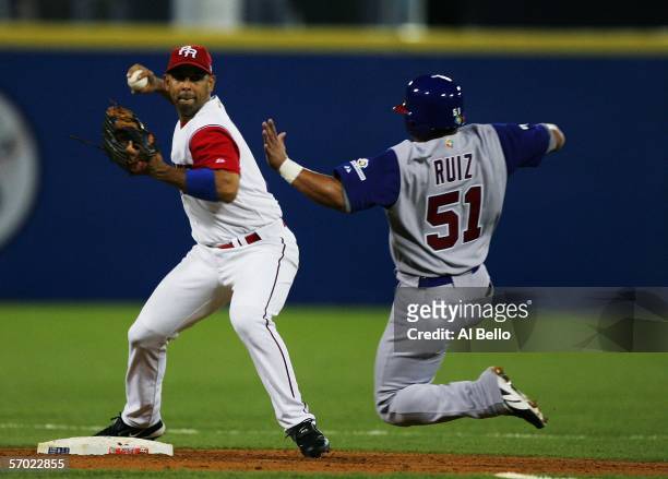 Alex Cora of Puerto Rico turns a double play as Carlos Ruiz of Panama is out at second base during their game at the World Baseball Classic at Hiram...