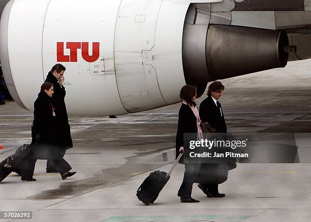 Crew members of LTU walk by a plane at the airport on March 8, 2006 in Munich, Germany. Rudolf Woehrl, owner of the airline dba and investor at the...