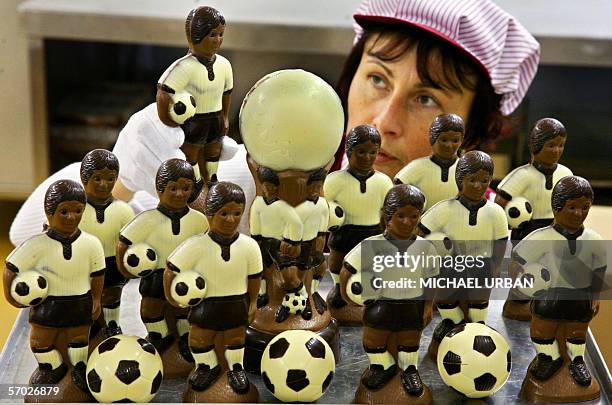 An employee of the Confiserie Felicitas chocolate manufacturer arranges football player figures made of chocolate 06 February 2006 at the company's...