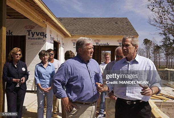 President George W. Bush speaks as Mississippi Governor Haley Barbour looks on during a visit to a home being rebuilt on the Mississippi Sound in...