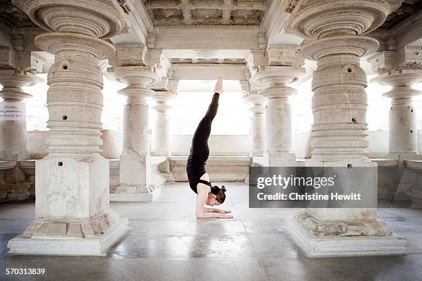 woman doing yoga in a temple - al revés posición descriptiva fotografías e imágenes de stock