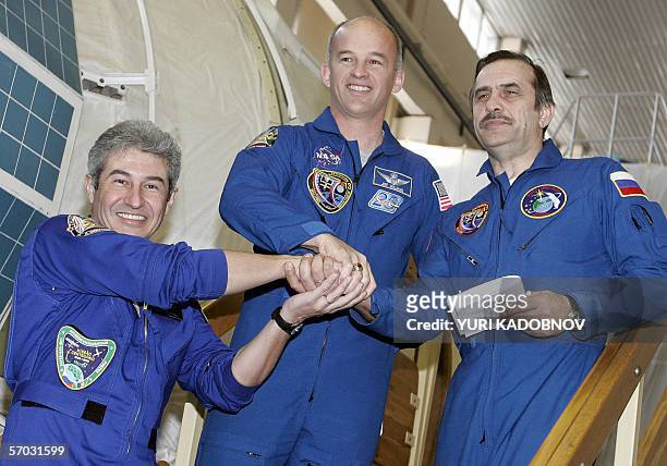 Russian cosmonaut Pavel Vinogradov , US astronaut Jeffry Williams and Brazilian Marcos Pontes shake hands prior to their training session in Star...
