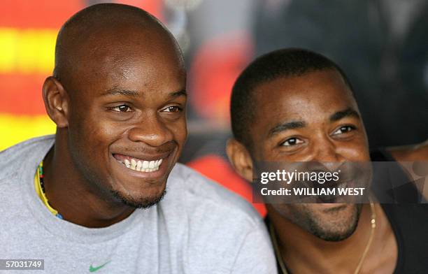 Jamaica's Asafa Powell poses in a photo with England's Darren Campbell after Jamaica win the men's 4x100m race at the IAAF World Athletics meet in...