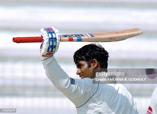 Sri Lankan cricketer Upul Tharanga raises hit bat in the air after scoring a century during the second day of the second Test Match between...