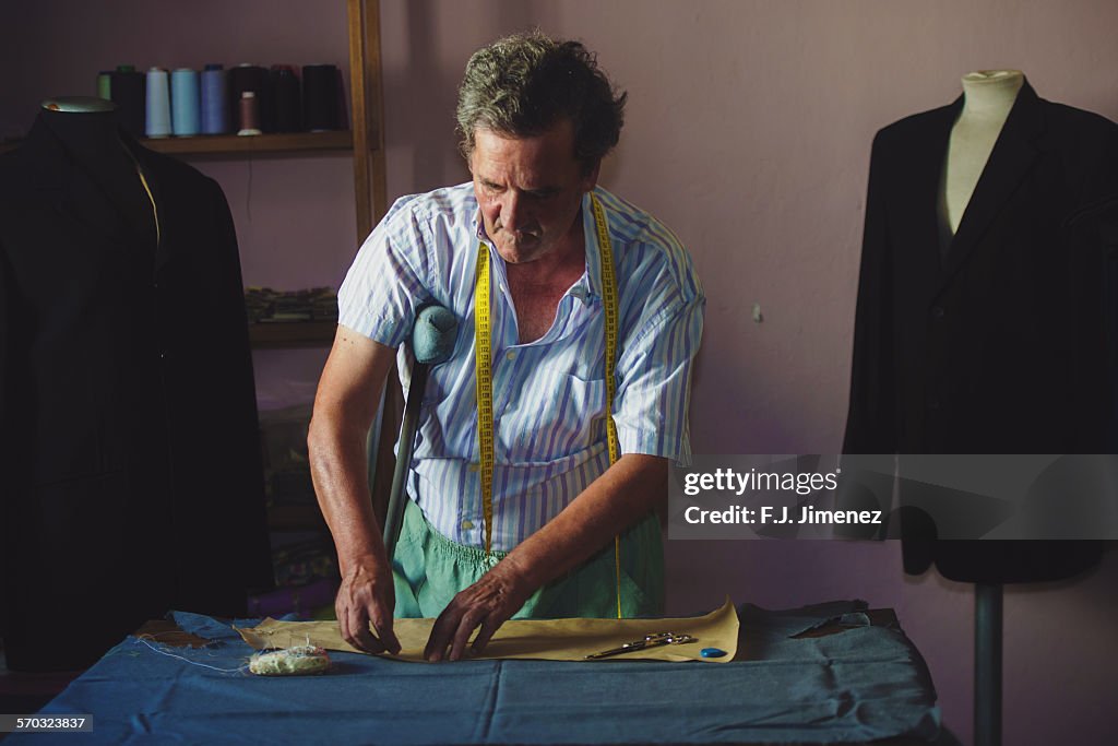 Elderly man sewing