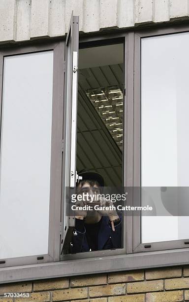 Babyshambles frontman Pete Doherty hangs out a window and plays his harmonica at court on March 9, 2006 in London, England. Doherty is appearing on...