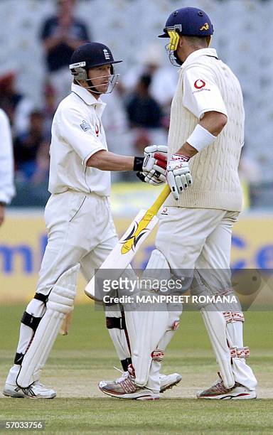 England cricketer Paul Collingwood congratulates teammate Kevin Pietersen after he completed his half century on first day of the second Test match...