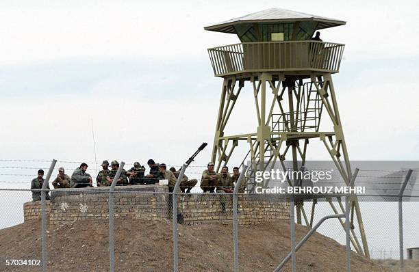 Iranian soldiers gather around an anti-aircraft machinegun inside the uranium enrichment facility in Natanz, 300 kms south of Tehran, as they watch a...