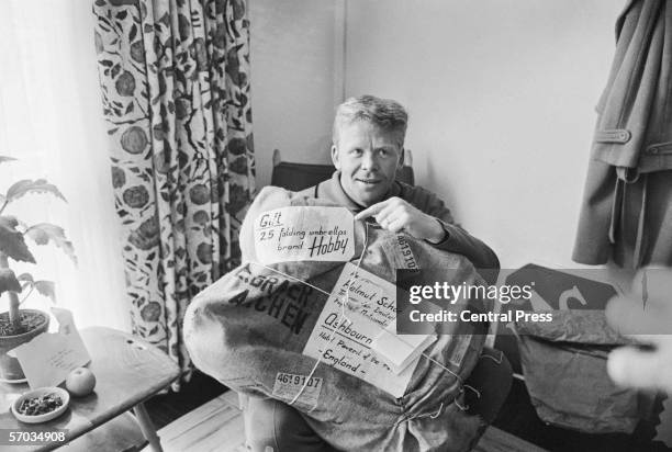 West German footballer Helmut Haller with a delivery of 25 folding umbrellas which have been sent to the team at their Derbyshire hotel to help them...