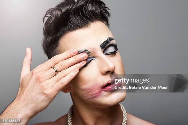 cross dresser smearing makeup of face - removing make up stock pictures, royalty-free photos & images