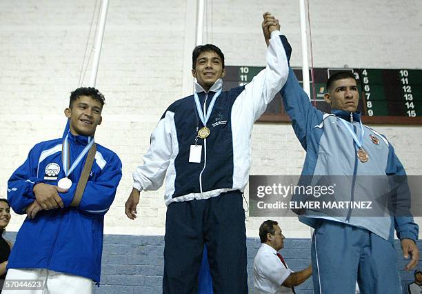 Tegucigalpa, HONDURAS: Kenny Hernandez of Honduras with silver medal, Douglas Rodriguez of Guatemala with gold and Jorge Korea of Nicaragua with...