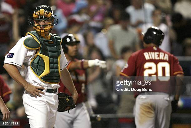 Catcher Michael Collins of Australia looks toward the bench after a sixth innning walk with the bases loaded scored Juan Rivera of Venezuela in a...